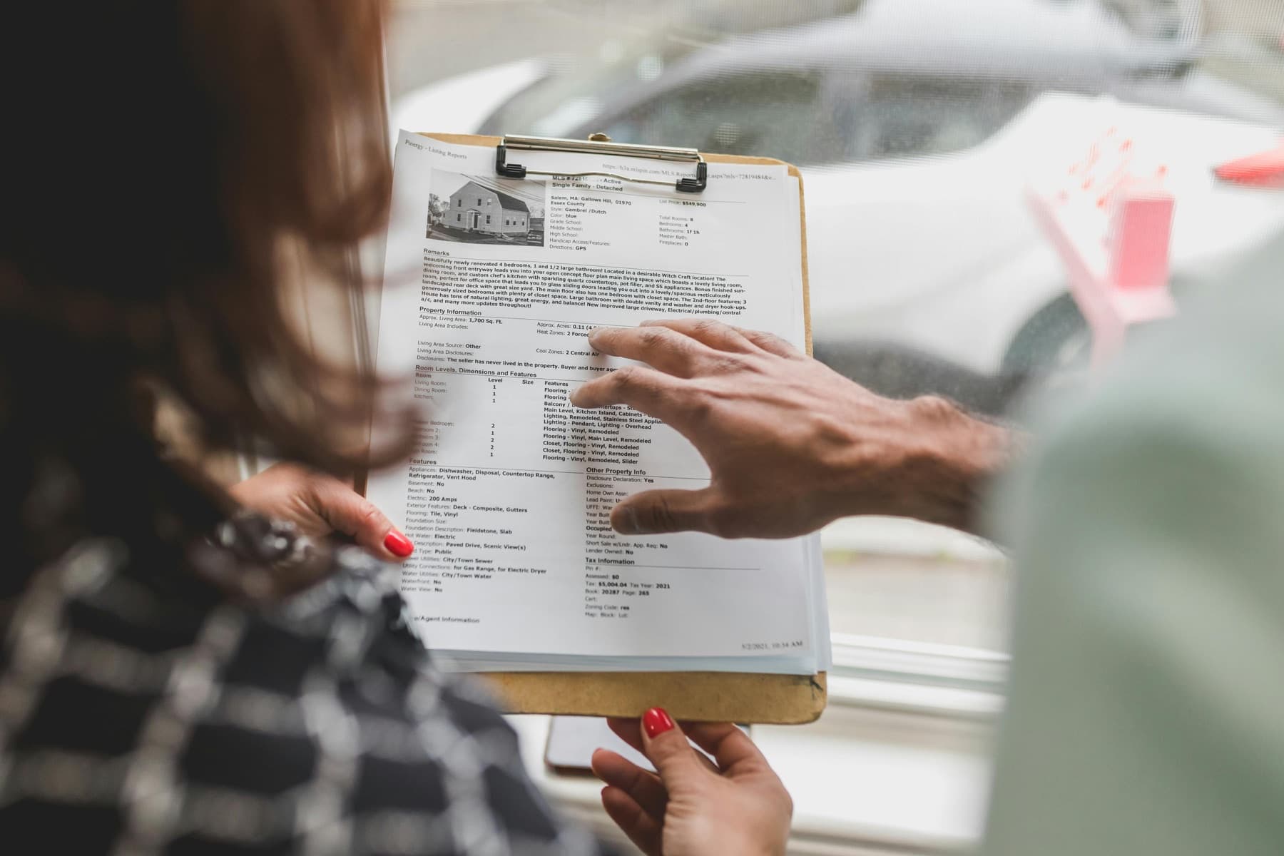 Real estate paperwork held on a clipboard.