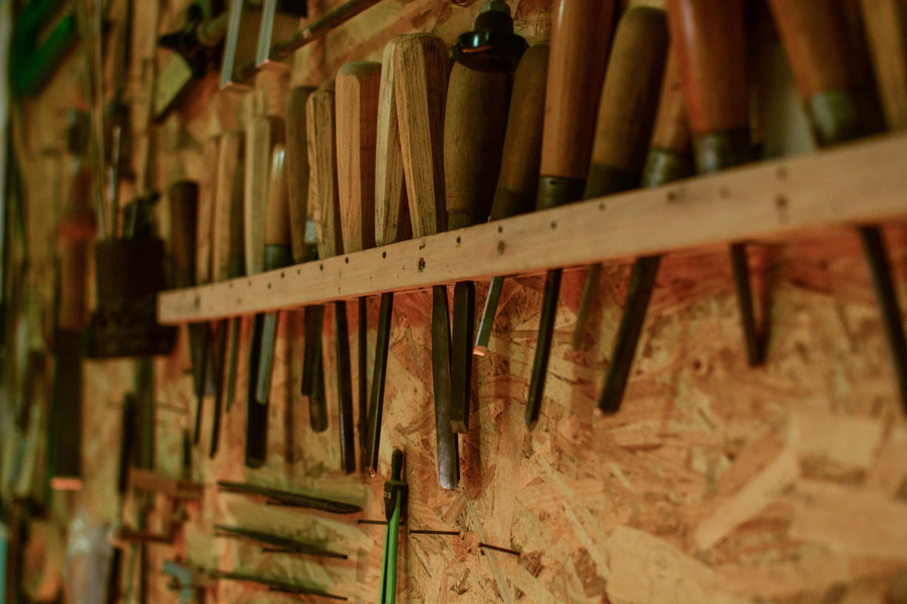 Hand tools hung in neat rows on a workshop wall.