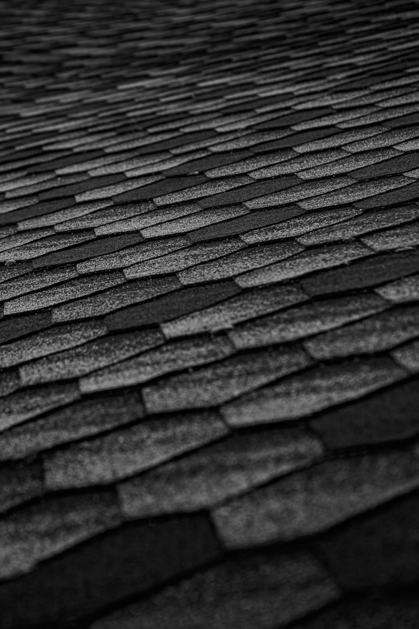 Close view of dark asphalt roof shingles.